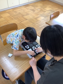 小学生の男の子と先生が動物将棋をしている写真。