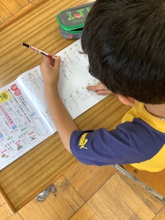 男の子が漢字ドリルを書き直している写真