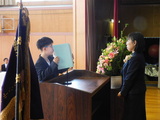 新入生代表の中学生がステージの上で校長先生に向かって言葉を述べている様子