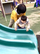 滑り台に触れる幼児の様子