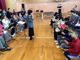 ハーモニカクラブの演奏に合わせて打楽器を演奏する小学部児童の様子