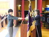 中学部卒業生男子が校長先生から卒業証書を授与されている場面