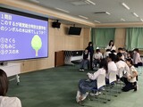 スクリーンを見てクイズを考えている写真