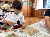 ハンマーで板に杭を打ち込む児童