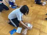 模擬のAEDのパットを人形に貼る生徒 模擬のAEDのパットを人形に貼る生徒