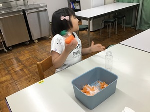 Yさんがお花紙とお湯の入ったペットボトルを振っている様子。