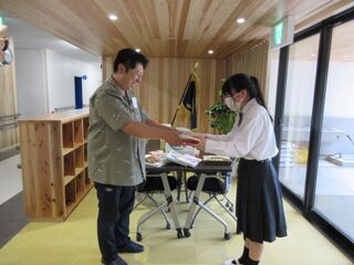 高等部の生徒が本を受け取っています