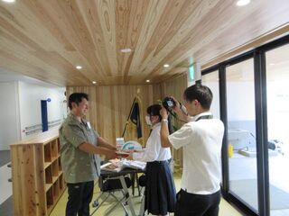 静岡新聞の記者の方が、本を受け取っている写真を撮っています
