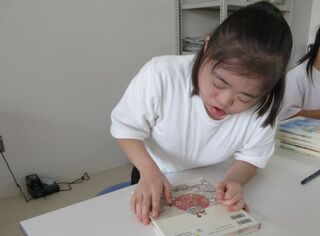 生徒が本の裏表紙を見ています