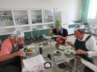 全員で作ったナス料理を試食している